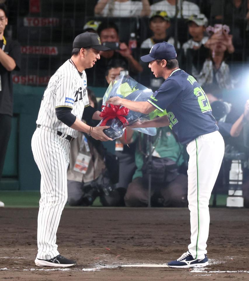 　今シーズンで辞任する高津監督（右）に花束を手渡す藤川監督（撮影・立川洋一郎）