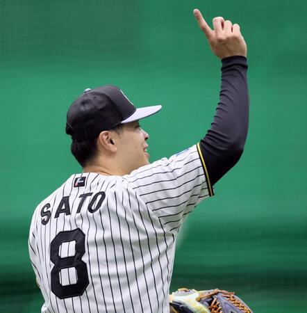 　ノックを受けて返球しストライクのポーズを見せる佐藤輝（撮影・立川洋一郎）