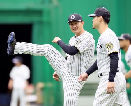 　佐藤輝（右）と話しながらウオーミングアップをする森下（撮影・立川洋一郎）