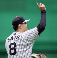 　ノックを受けて返球しストライクのポーズを見せる佐藤輝（撮影・立川洋一郎）