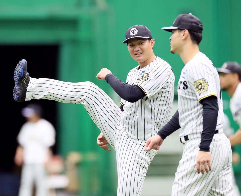 　佐藤輝（右）と話しながらウオーミングアップをする森下（撮影・立川洋一郎）