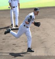 　ノックの打球をバックトスで返球する佐藤輝（撮影・北村雅宏）