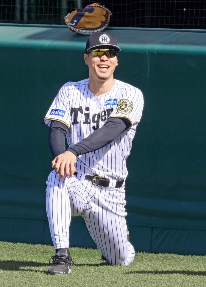 　ウオーミングアップしながら笑顔を見せる佐藤輝（撮影・立川洋一郎）