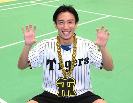 持参した虎メダルとユニホームを着てポーズを決める桃田賢斗（撮影・堀内翔）