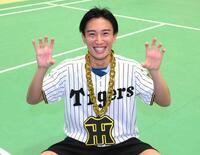 持参した虎メダルとユニホームを着てポーズを決める桃田賢斗（撮影・堀内翔）