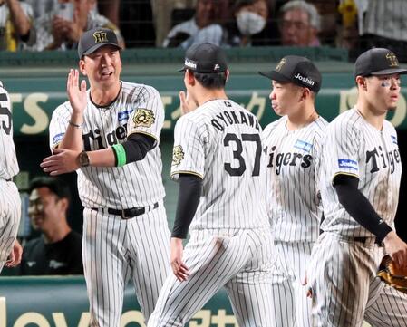 　ＣＳファイナル初戦を勝利し、ナインとタッチを交わす藤川監督（左）＝撮影・立川洋一郎