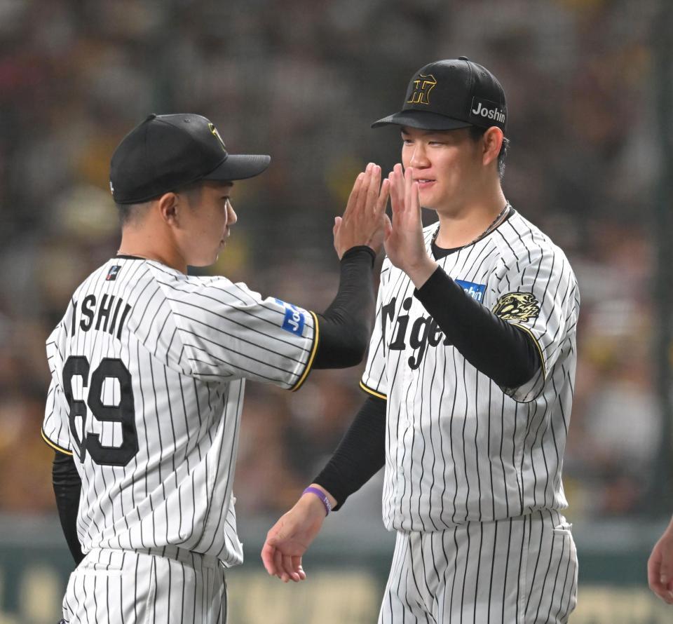 　７回、石井をハイタッチで迎える及川（撮影・飯室逸平）