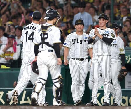 　８回、ピンチを防いだ岩貞（１４）を迎える湯浅（右）＝撮影・北村雅宏