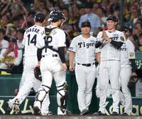 　８回、ピンチを防いだ岩貞（１４）を迎える湯浅（右）＝撮影・北村雅宏