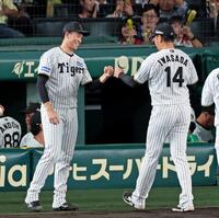 　８回を無失点で切り抜け、リリーフした岩貞（１４）とタッチを交わす湯浅（撮影・立川洋一郎）