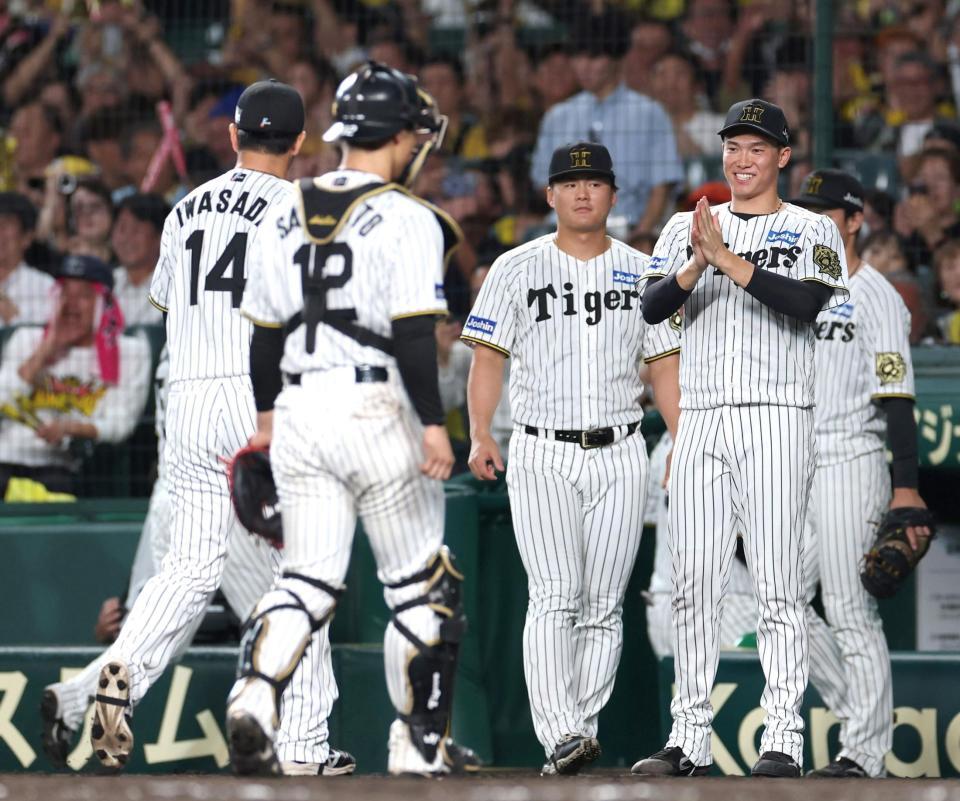 　８回、ピンチを防いだ岩貞（１４）を迎える湯浅（右）＝撮影・北村雅宏