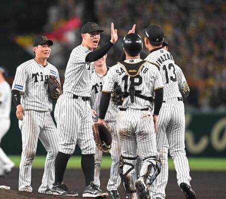 　日本シリーズ進出を決め、ハイタッチで勝利を喜ぶ佐藤輝ら阪神ナイン（撮影・飯室逸平）