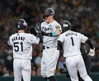 　１回、先制３ランを放ち、中野（５１）と森下（１）に迎えられる佐藤輝（撮影・西田忠信）