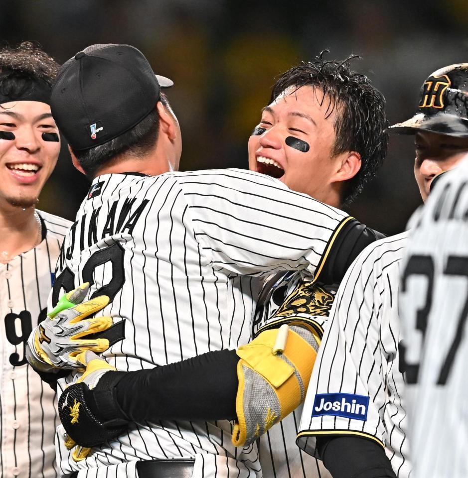 　１０回、サヨナラ２ランを放ち藤川監督（左）と抱き合う森下＝１６日