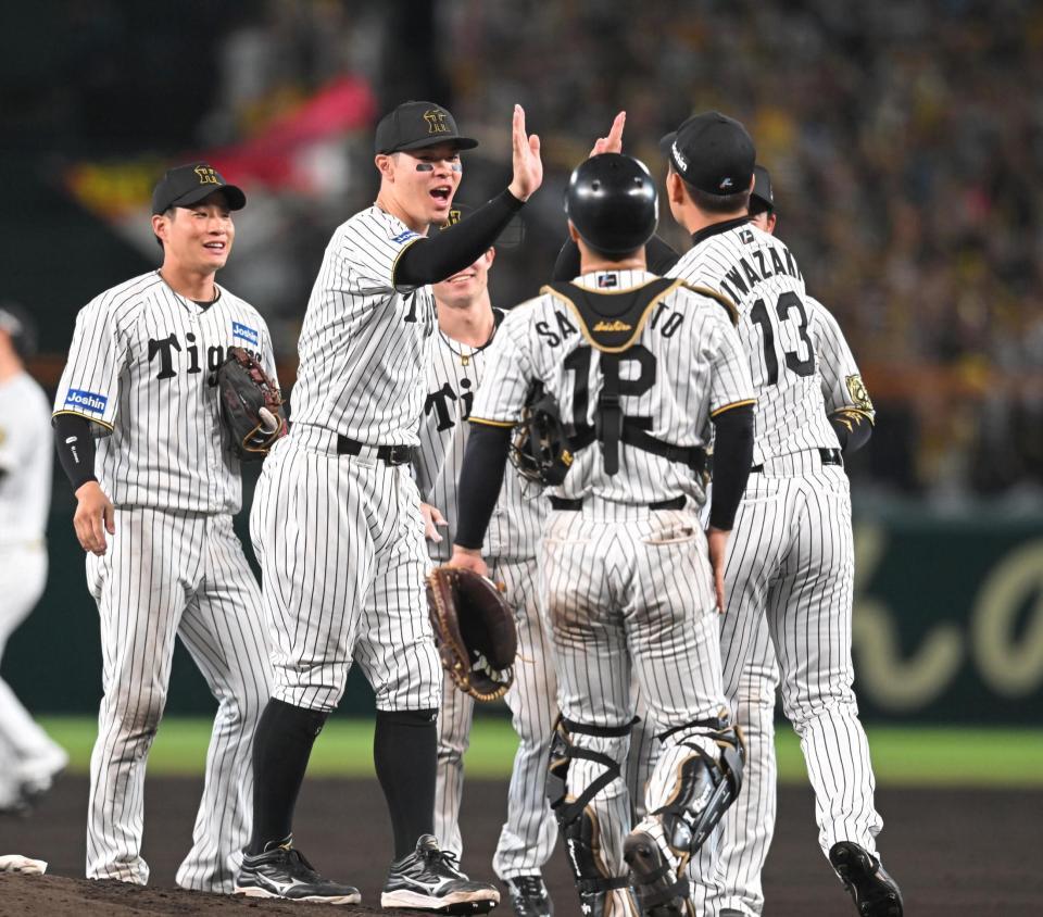 　日本シリーズ進出を決め、ハイタッチで勝利を喜ぶ佐藤輝ら阪神ナイン（撮影・飯室逸平）