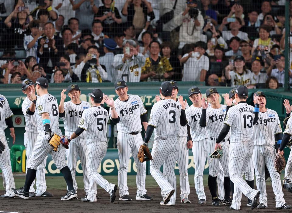 日本シリーズ進出を決め、勝利のタッチを交わす阪神・藤川球児監督（中央）ら阪神ナイン＝甲子園（撮影・立川洋一郎）