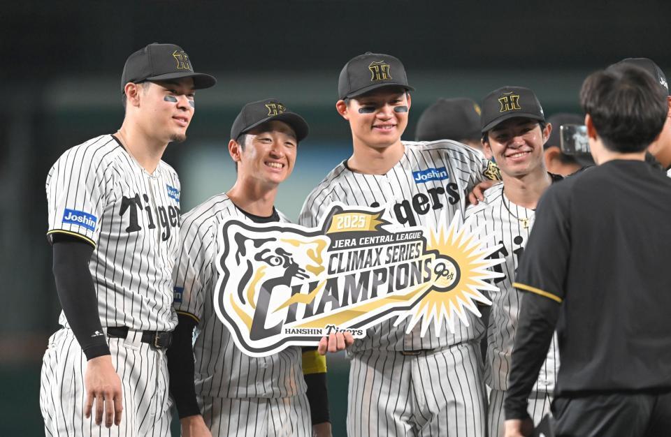 　チャンピオンボードを手に記念撮影する（左から）佐藤輝、近本、森下、中野（撮影・飯室逸平）