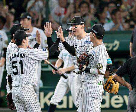 　日本シリーズ進出を決め、ナインと勝利のタッチを交わす佐藤輝ら阪神ナイン（撮影・田中太一）