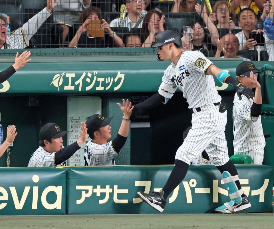 　１回、先制３ランを放った佐藤輝（手前）とタッチを交わす藤川監督（撮影・立川洋一郎）