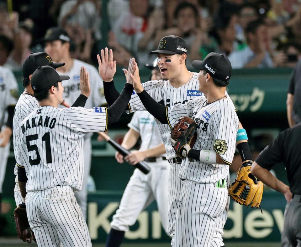 　日本シリーズ進出を決め、ナインと勝利のタッチを交わす佐藤輝ら阪神ナイン（撮影・田中太一）