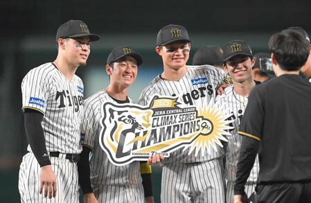 　チャンピオンボードを手に記念撮影する（左から）佐藤輝、近本、森下、中野＝１７日