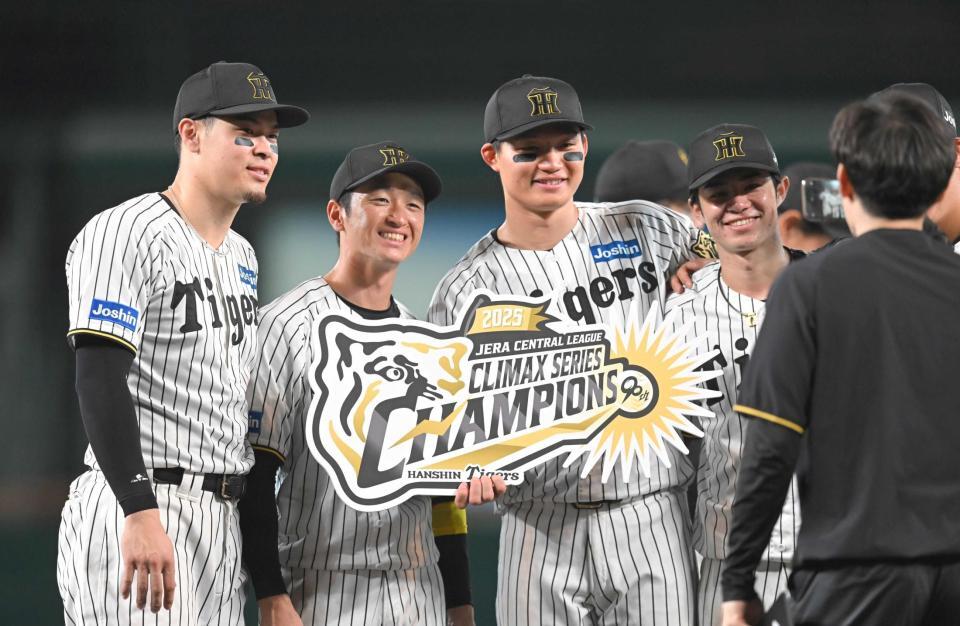 　チャンピオンボードを手に記念撮影する（左から）佐藤輝、近本、森下、中野＝１７日