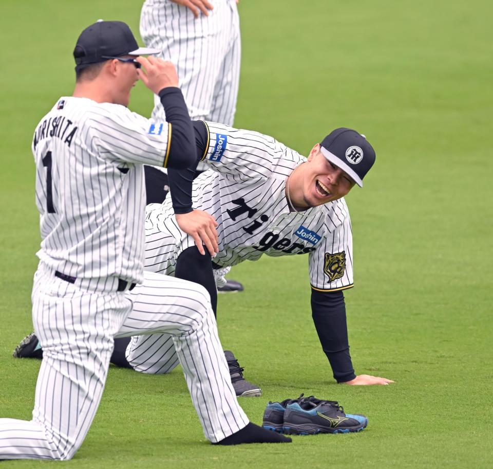 　森下と談笑する佐藤輝（撮影・飯室逸平）