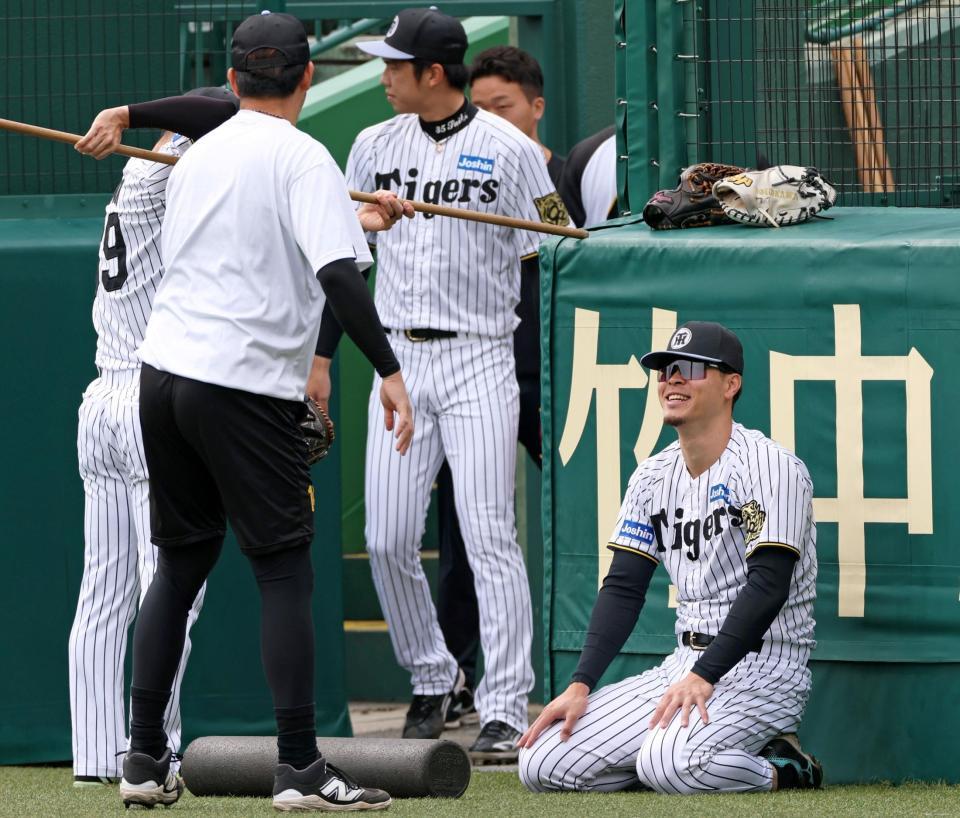 　ウオーミングアップをしながら談笑する佐藤輝（右）＝撮影・立川洋一郎