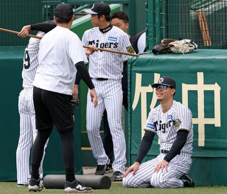 　ウオーミングアップをしながら談笑する佐藤輝（右）＝２１日