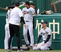 　ウオーミングアップをしながら談笑する佐藤輝（右）＝撮影・立川洋一郎