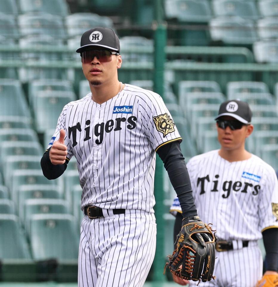 　サムアップポーズを見せる佐藤輝＝２１日