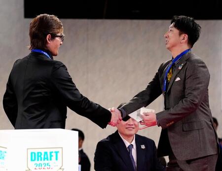 　創価大・立石正広の交渉権を獲得し、新庄監督（左）と握手を交わす藤川監督