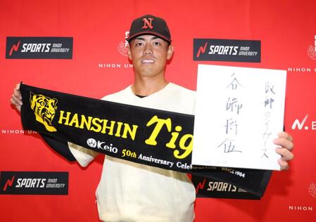 　サインを手に笑顔の日大・谷端将伍（撮影・金田祐二）