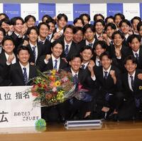 　阪神から１位指名を受け、笑顔でガッツポーズする創価大・立石正広（中央）＝撮影・西岡正