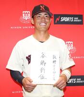 　サインを手に笑顔の日大・谷端将伍（撮影・金田祐二）