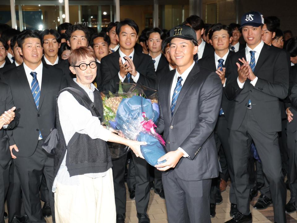 　母・郁代さん（左）に花束を渡す創価大・立石正広（撮影・西岡正）