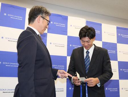 　吉野スカウト（左）から当たりくじを受け取る創価大・立石正広（撮影・石井剣太郎）
