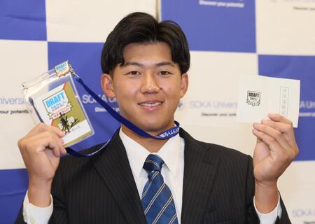 　当たりくじを手にポーズを決める創価大・立石正広（撮影・石井剣太郎）