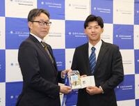 　吉野スカウト（左）から当たりくじを受け取る創価大・立石正広（撮影・石井剣太郎）