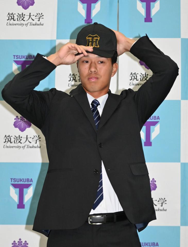 　帽子をかぶる阪神３位・岡城快生（撮影・持木克友）