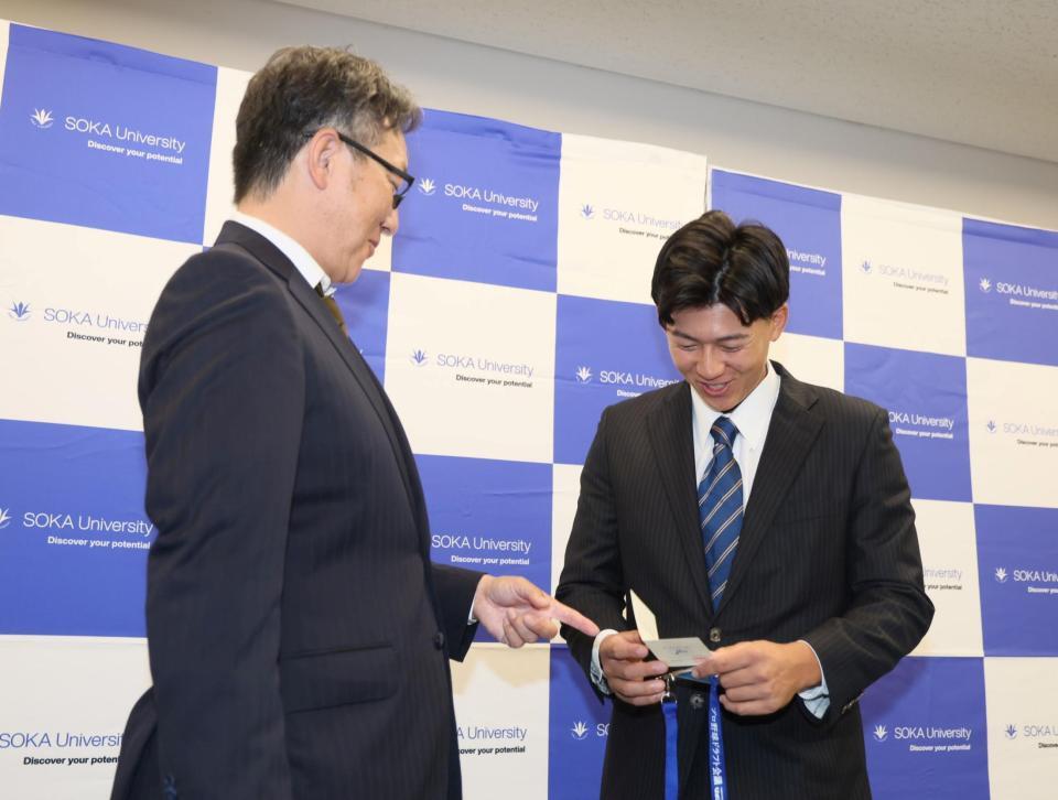 　吉野スカウト（左）から当たりくじを受け取る創価大・立石正広（撮影・石井剣太郎）