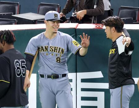 　岩貞（右）とウオーミングアップをしながら談笑する佐藤輝（撮影・立川洋一郎）