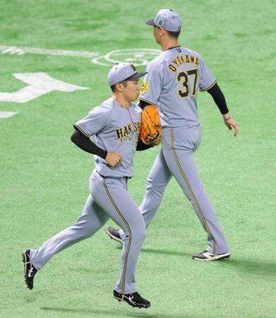 　８回、及川（右）に代わってマウンドへ向かう石井（撮影・立川洋一郎）