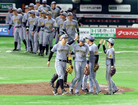 　日本シリーズ初戦を制し喜ぶ佐藤輝（中央）ら阪神ナイン（撮影・山口登）