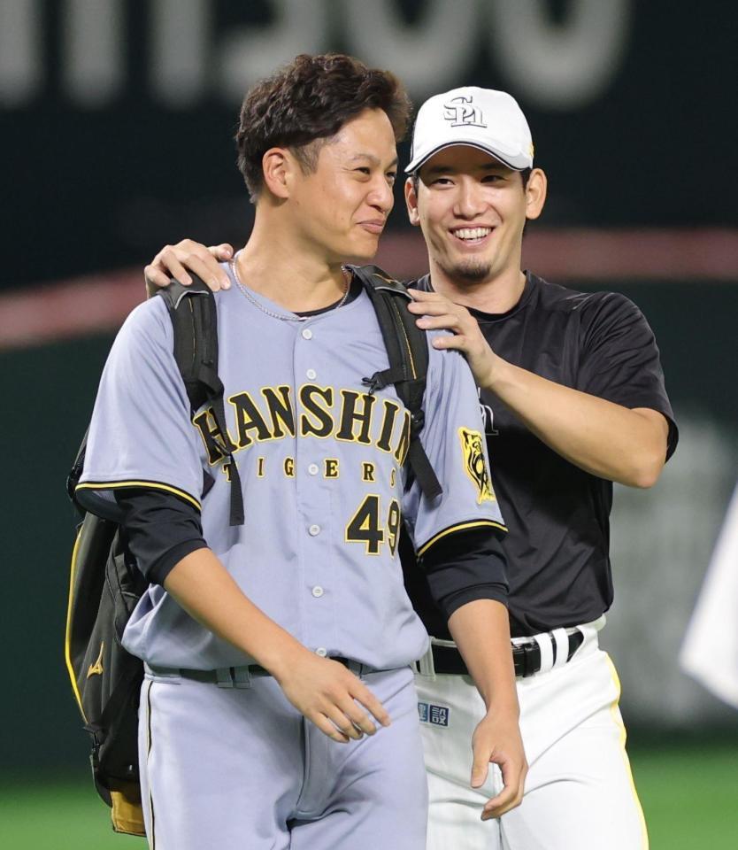 　栗原（右）に肩をもまれる大竹（撮影・西岡正）