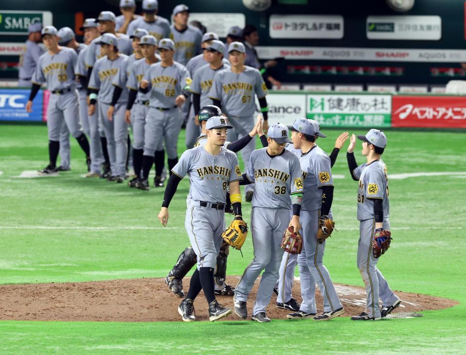 　日本シリーズ初戦を制し喜ぶ佐藤輝（中央）ら阪神ナイン（撮影・山口登）