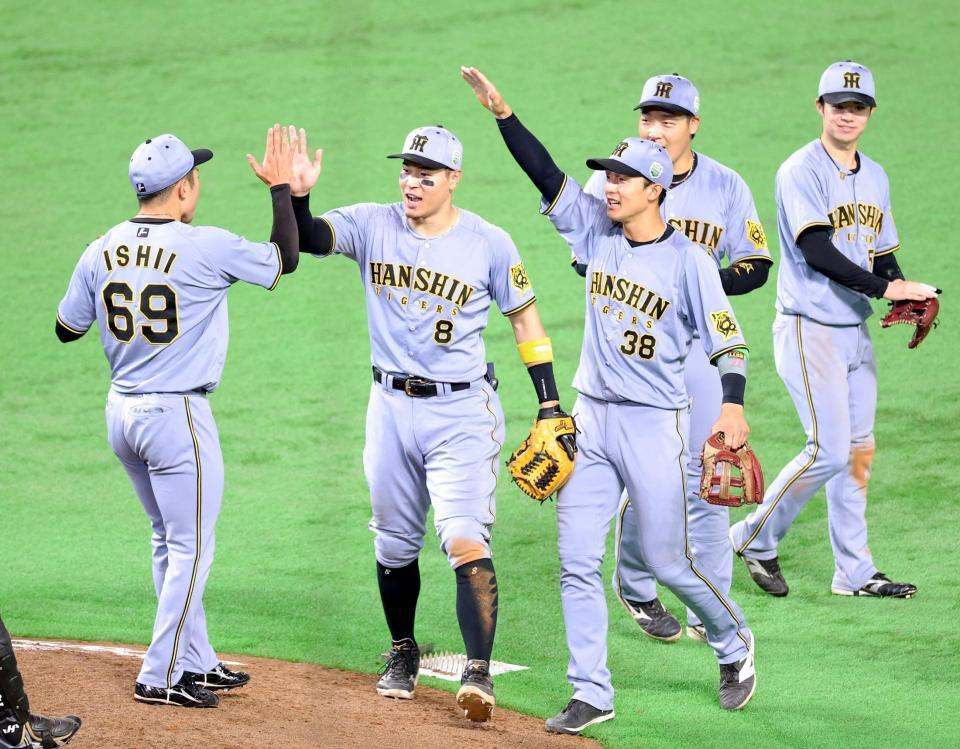 　日本シリーズ初戦を勝利しタッチを交わす佐藤輝（８）ら阪神ナイン（撮影・立川洋一郎）