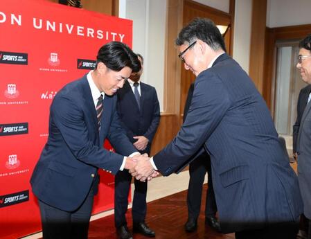 　ドラフト２位指名され、担当の吉野誠スカウト（右）からあいさつを受ける日大・谷端将伍（撮影・伊藤笙子）