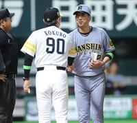 　メンバー表交換で握手する小久保監督（手前）と藤川監督（撮影・西岡正）