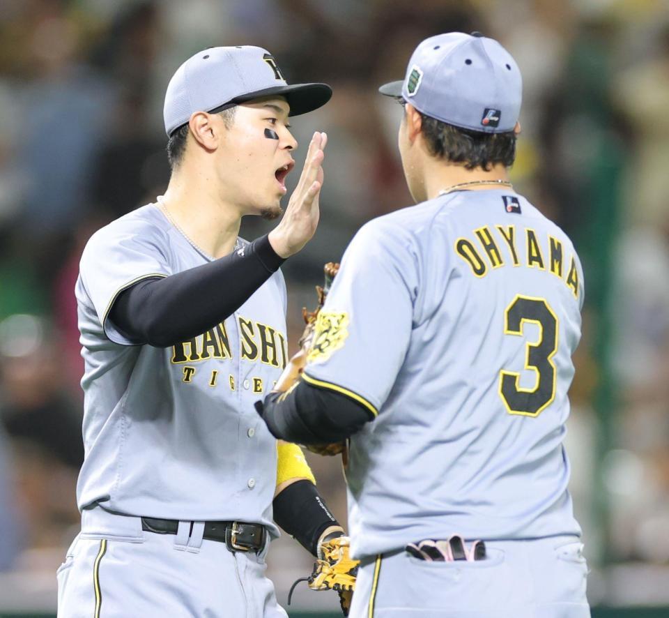 　ソフトバンクに勝利し、大山（右）とタッチを交わす佐藤輝（撮影・西岡正）